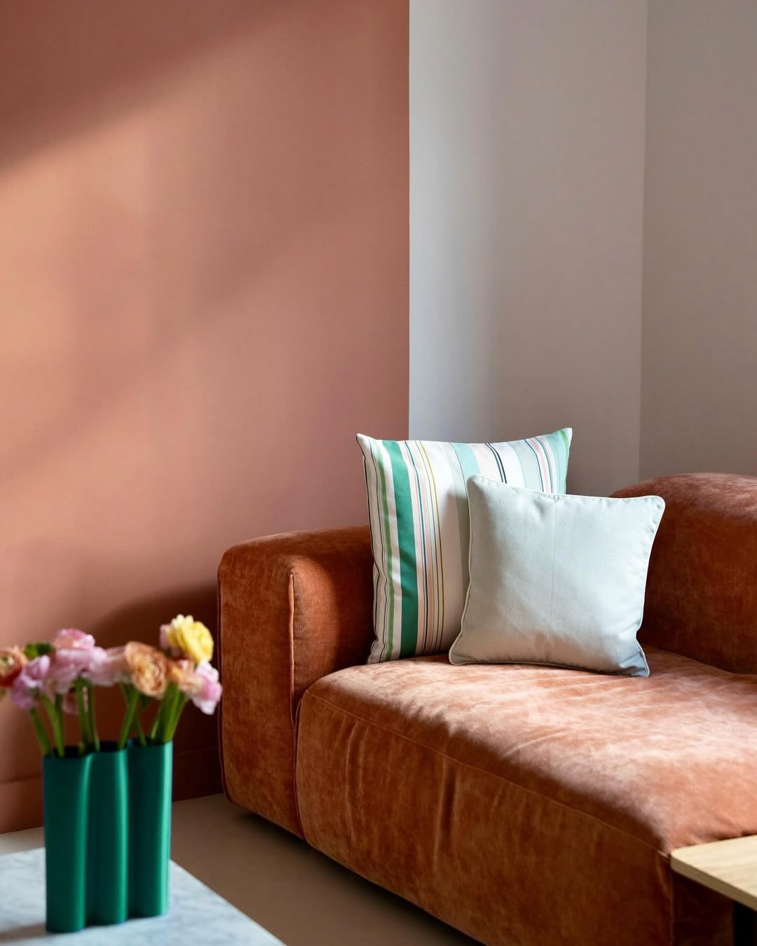 Brown sofa with colourful Bompas pillows against a pink wall