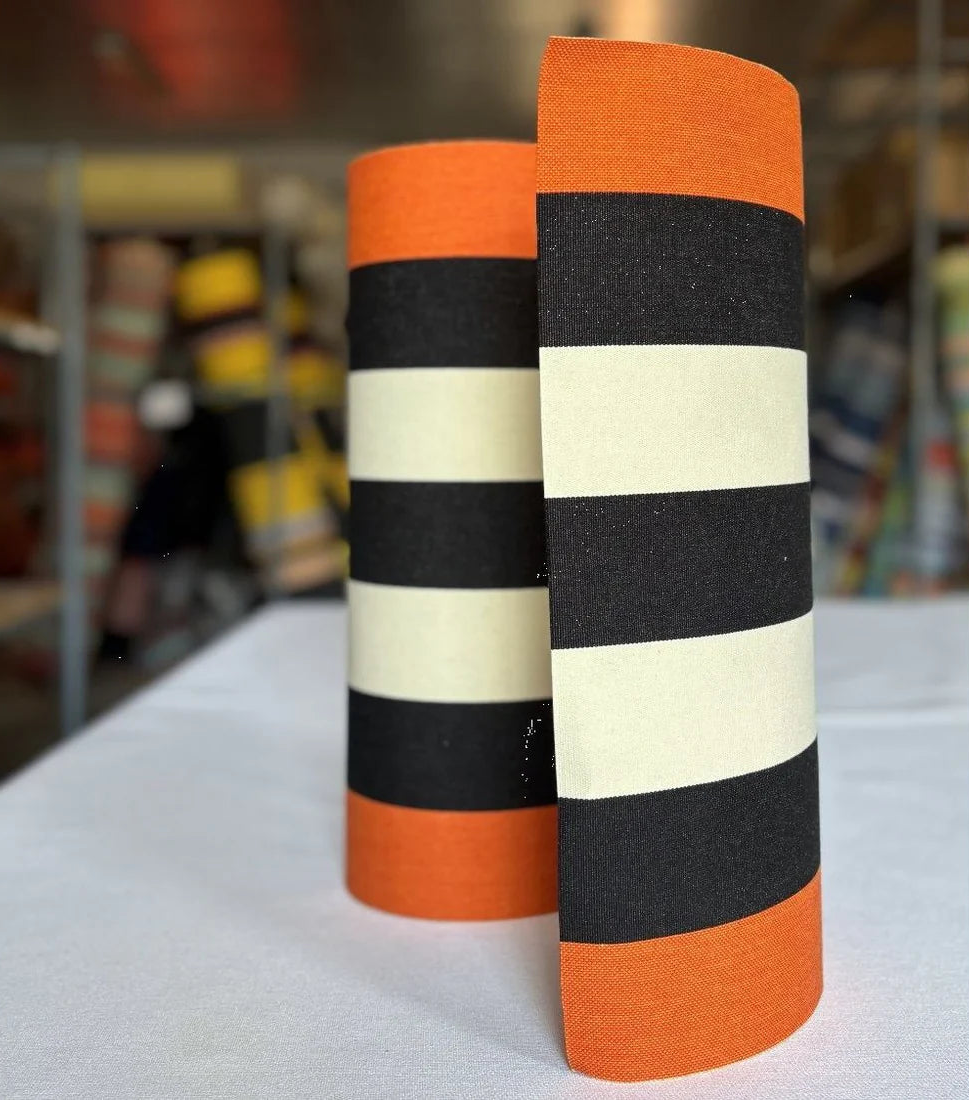 Bold thick striped fabric roll with black, ecru beige and rust colour on the sides.