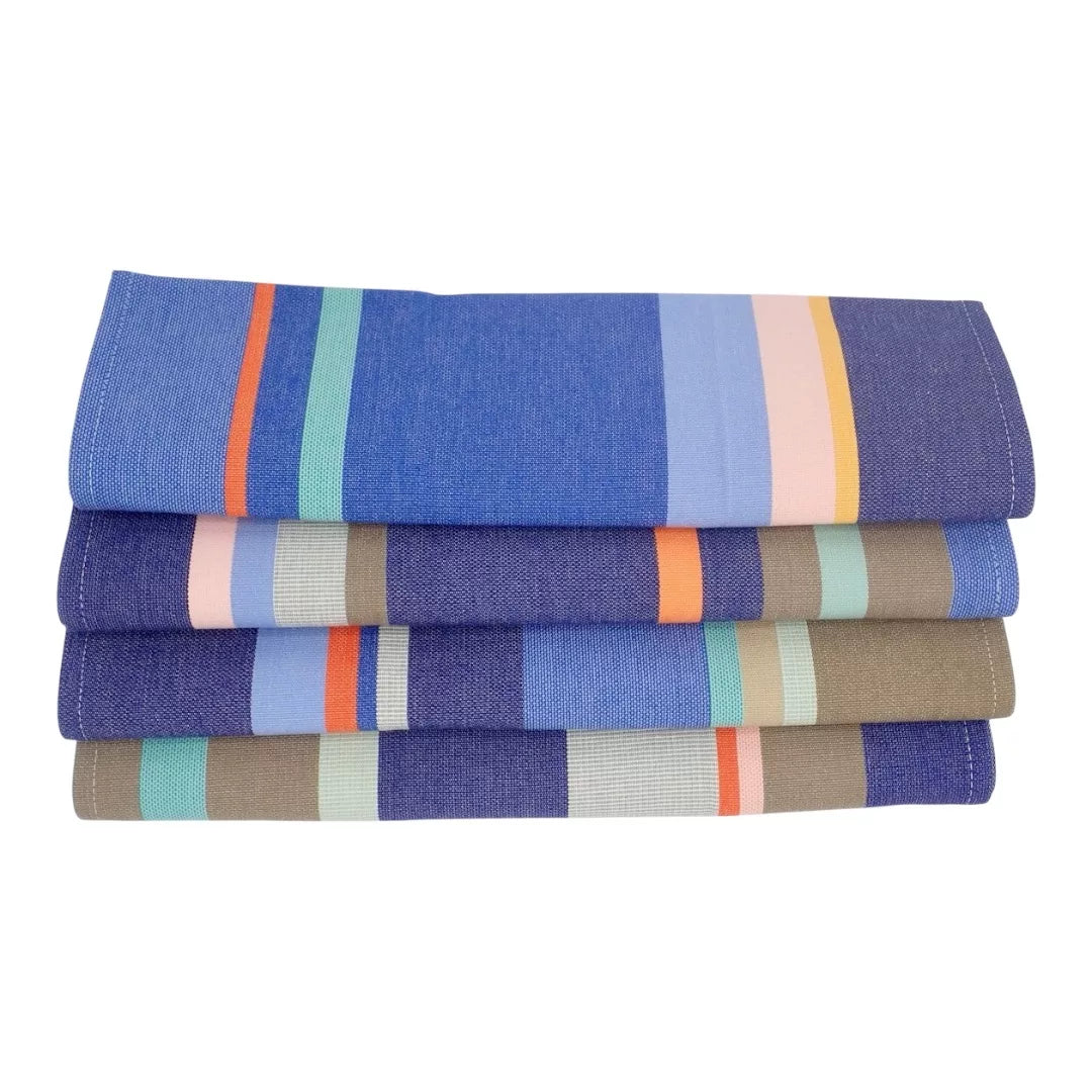 Stack of folded Collioure Roy 100% cotton Les toiles du Soleil fabric. Multi coloured striped with blues shades yellow, beige and red, on a white background