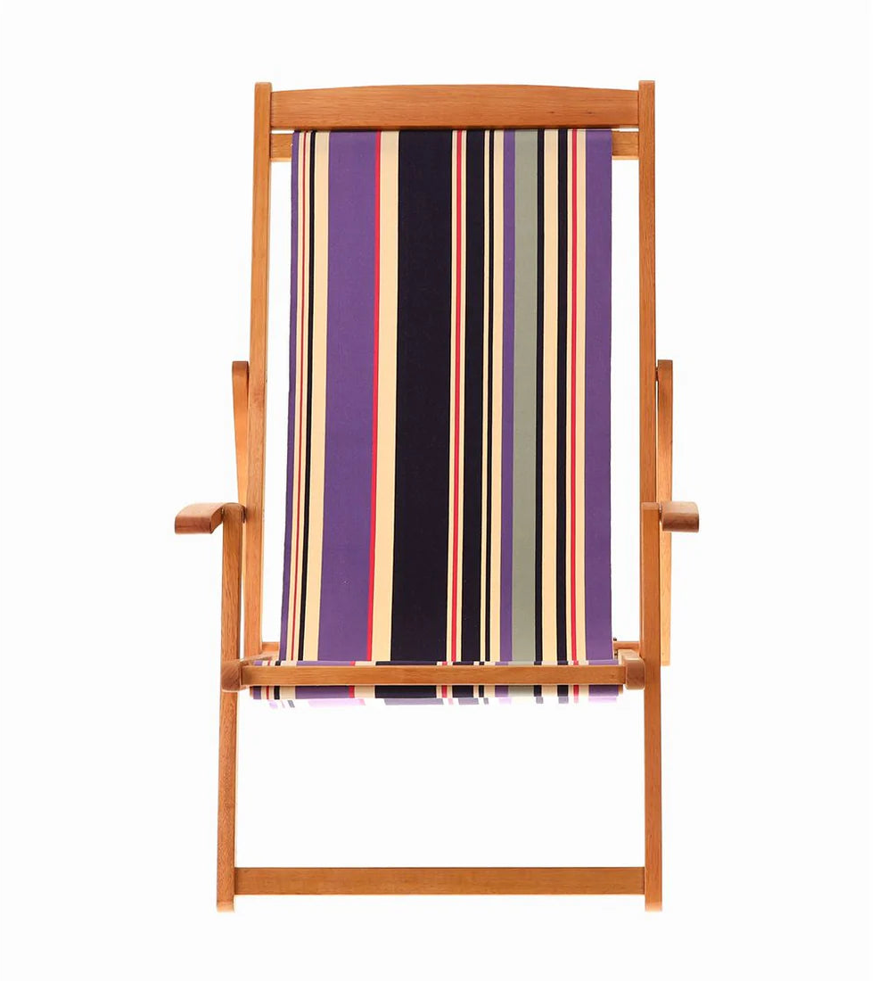 Wooden deckchair with fabric featuring navy, violet, and ivory stripes accented by fine crimson lines. On a white background