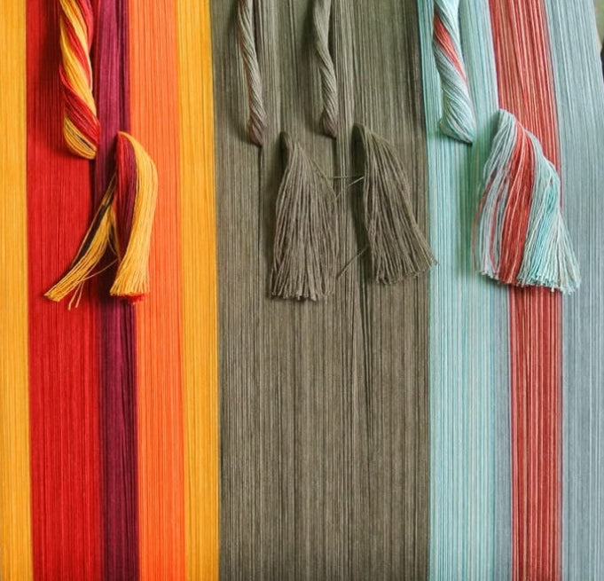 Colourful Les Toiles du Soleil fabric on a loom with a black background