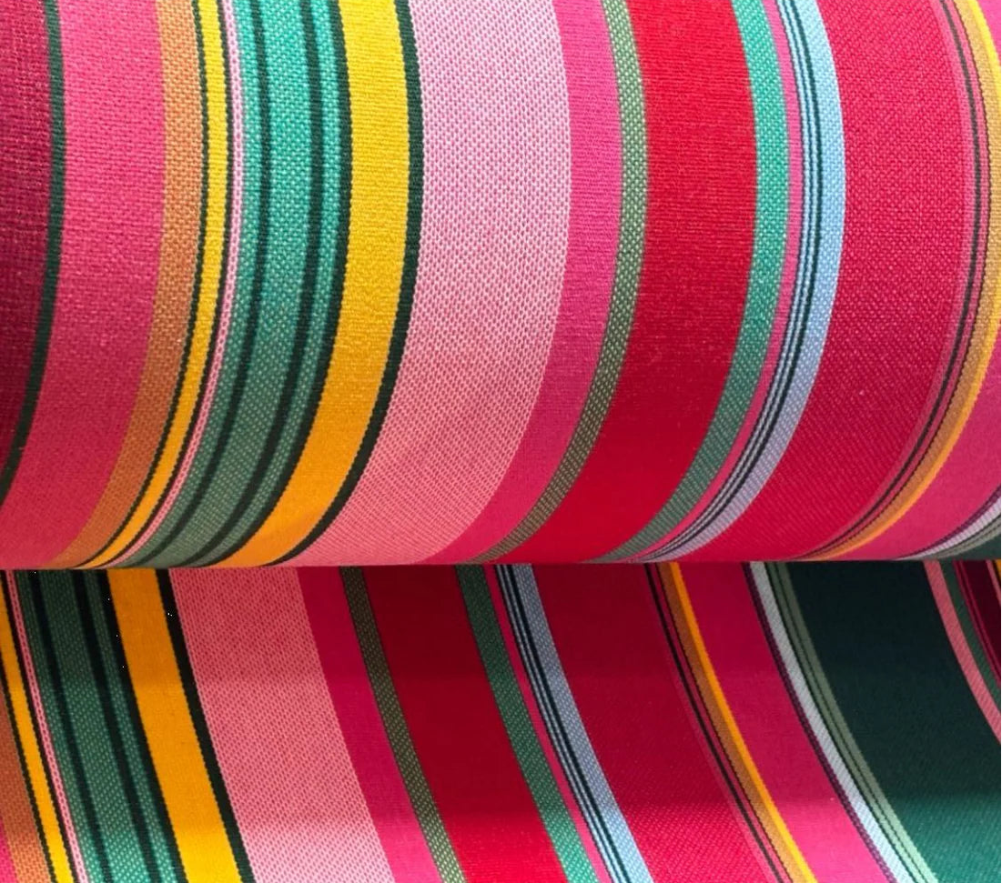 Cotton fabric roll featuring stripes of red, purplish crimson, candy pink, green, blue and golden yellow, inspired by the colours of the Catalan town of Toulouges and its famous onion.