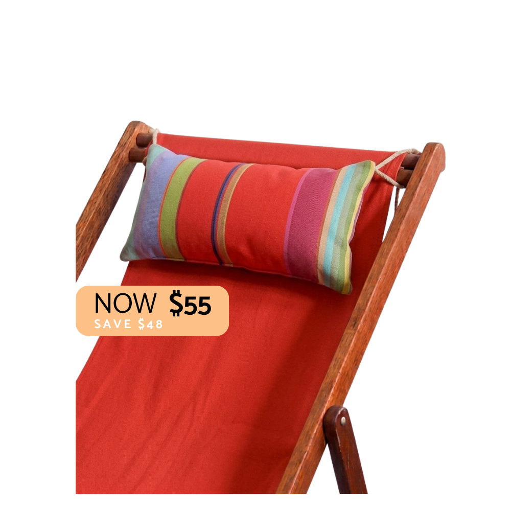 Multi-striped head cushion with reds, greens, lilac, teals, and crimson stripes. Placed on a red deckchair sling and a "Now $55" sign. On a plain background