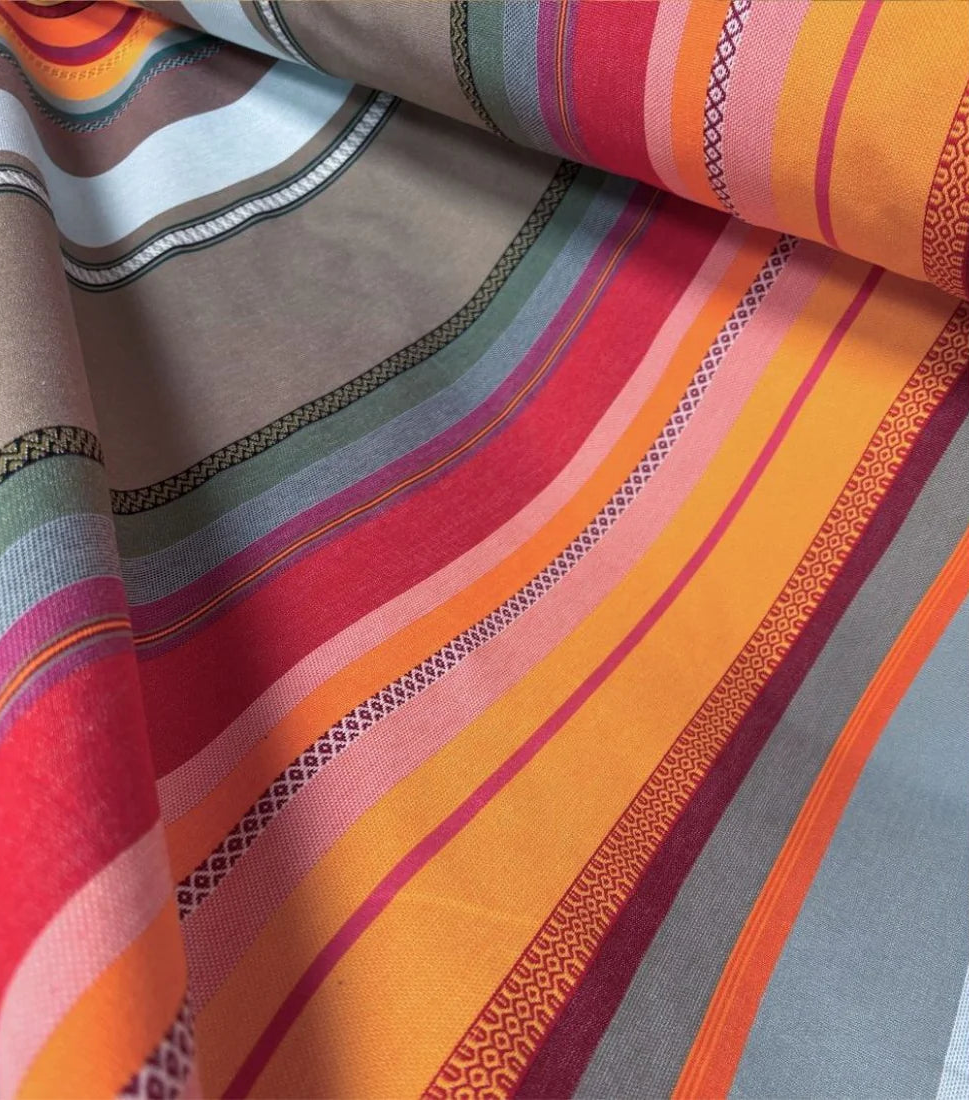 Close up of Les Toiles du Soleil Arles sur Tech multi coloured grey, red, yellow and orange fabric