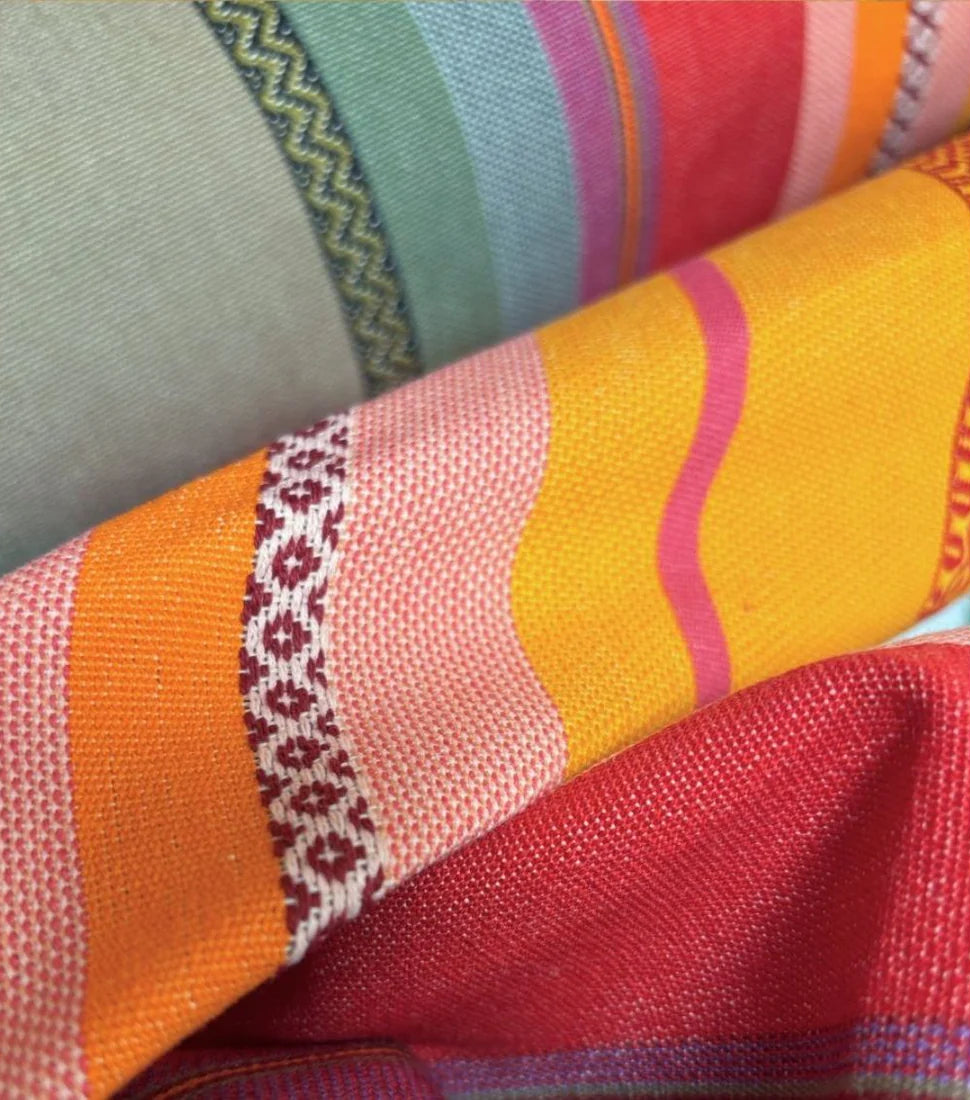 Close up of Les Toiles du Soleil Arles sur Tech multi coloured grey, red, yellow and orange fabric