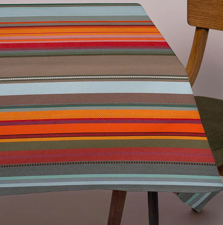 Close up of Les Toiles du Soleil Arles sur Tech multi coloured grey, red, yellow and orange fabric table cloth