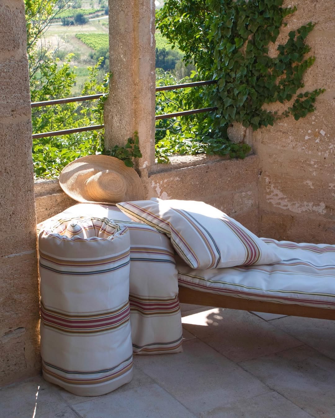 Outdoor seating area with Auguste striped cushions and sun lounger mattress.