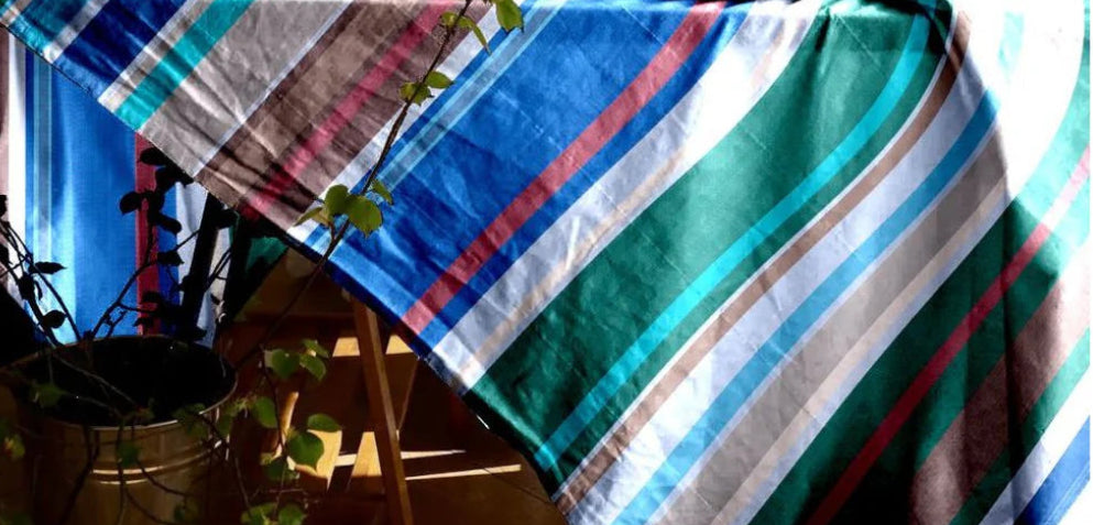 Tablecloth cotton fabric by Les Toiles du Soleil. Baikal is stripes of lavender, turquoise, green, navy, beige, and white