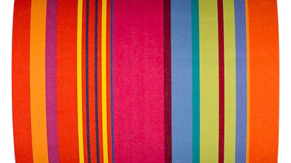 Bonbon Plume 43cm fabric featuring a striped pattern with vibrant stripes of orange, pink and red, punctuated with anise and fine bluish stripes. A detailed 100% cotton weave by By Les Toiles du Soleil