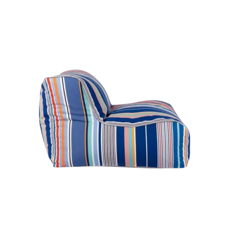 Large soft armchair made from Aigue Marine, which is a multi coloured striped fabric made by Les toiles du Soleil. It showcases a variety of shades of blue, pink, red turquoise, greens and other vibrant colours.
