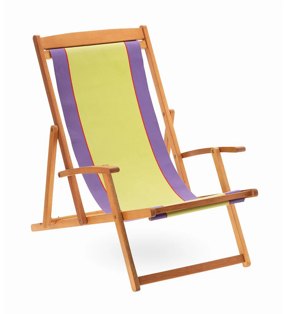 Wooden deckchair with Camino Violet cotton fabric. Featuring a bold middle stripe in lime with purple edges. Between the lime and purple is a thin fuchsia/red stripe. White background.