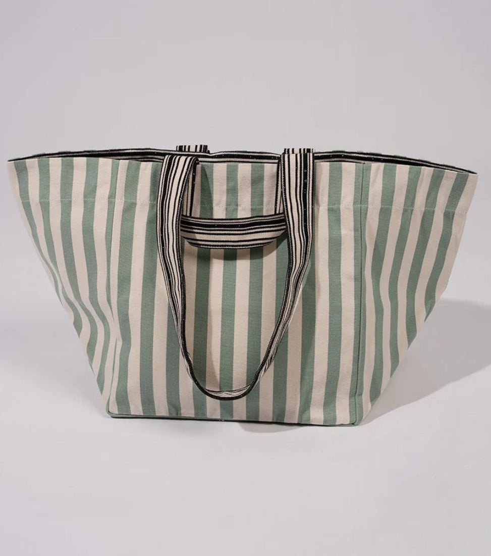 Large shoulder carry bag made of cotton fabric featuring even stripes of soft sage/almond green and crisp white. Made by Les Toiles du Soleil. White background