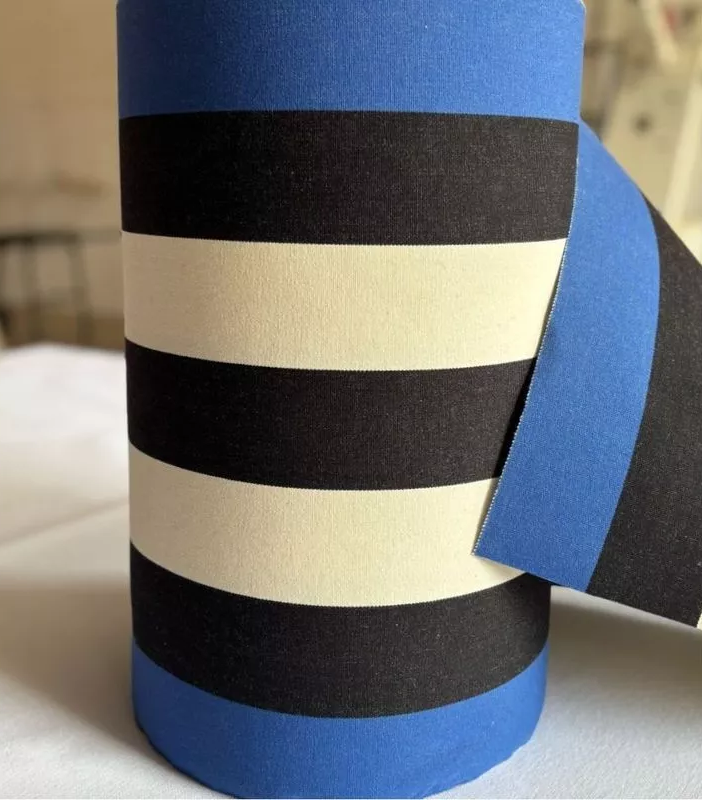 Close up of carthage Roy fabric. A bold cotton fabric featuring black and off- white, natural coloured stripes in between marine blue edges. Made by Les Toiles du Soleil