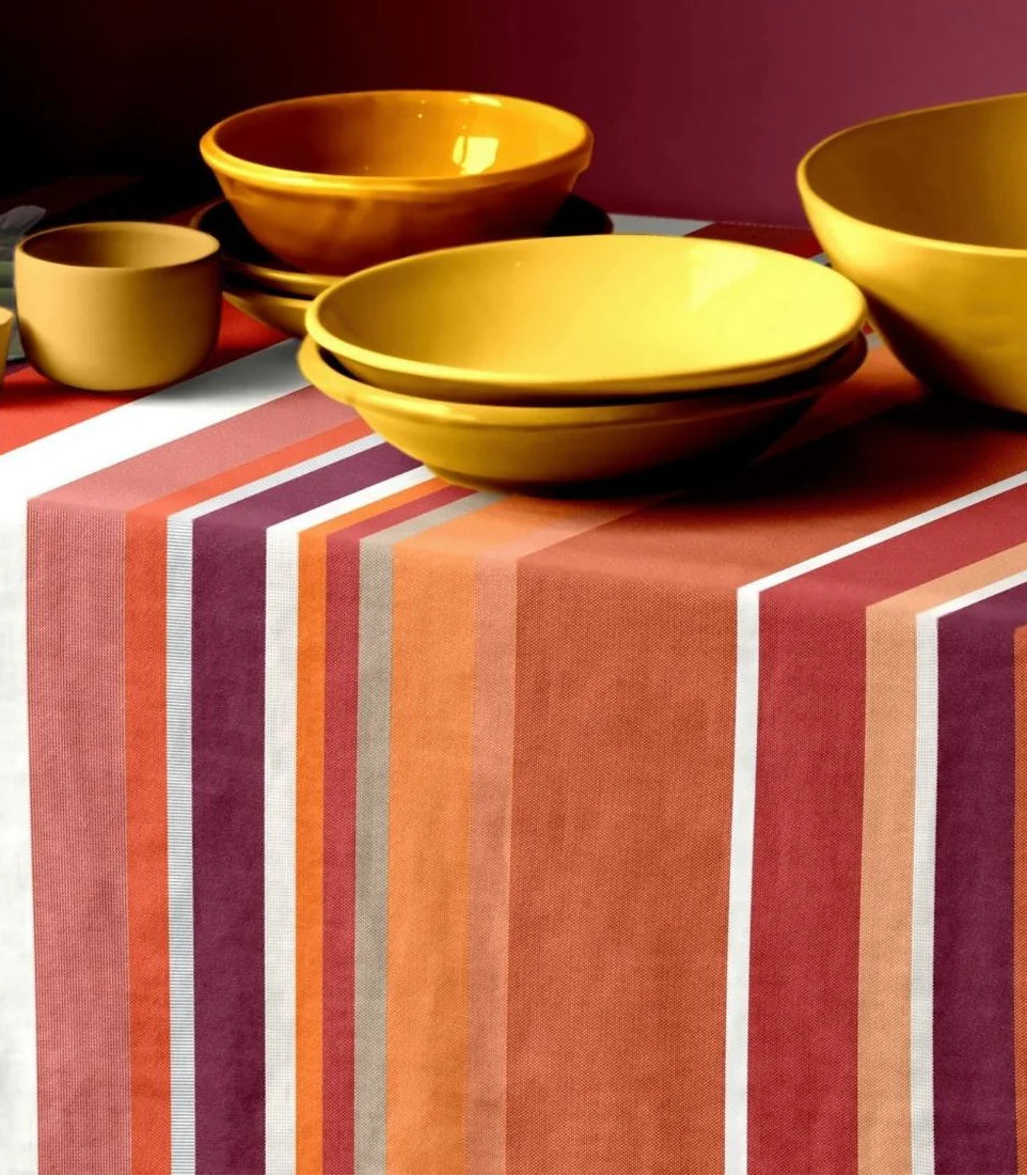 Les Toiles du Soleil 100% cotton fabric Crayou. Multi terracotta coloured striped fabric table cloth with yellow ceramic bowls and plates