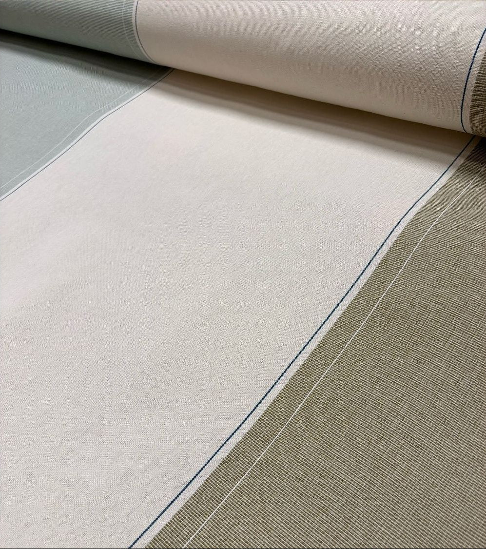 Close-up of Les Toiles du Soleil 100% Charlotte Bronze fabric with a checkered pattern and blue stitching detail.