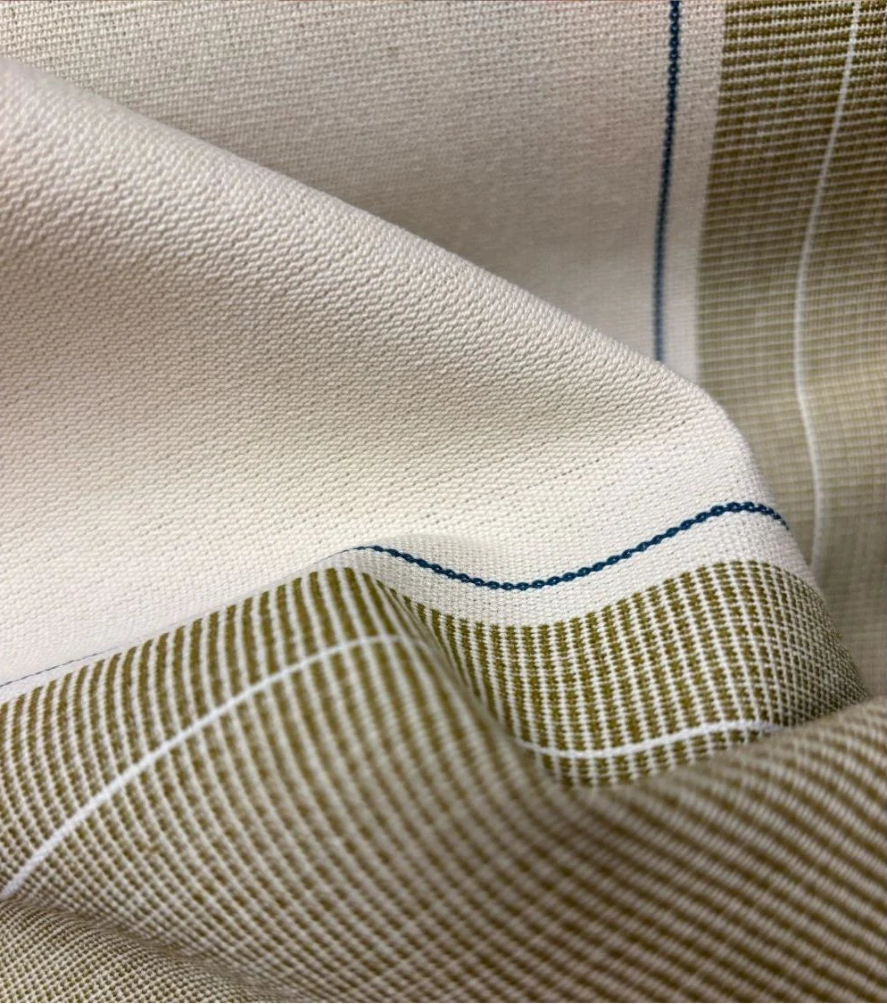 Close-up of Les Toiles du Soleil 100% Charlotte Bronze fabric with a checkered pattern and blue stitching detail.