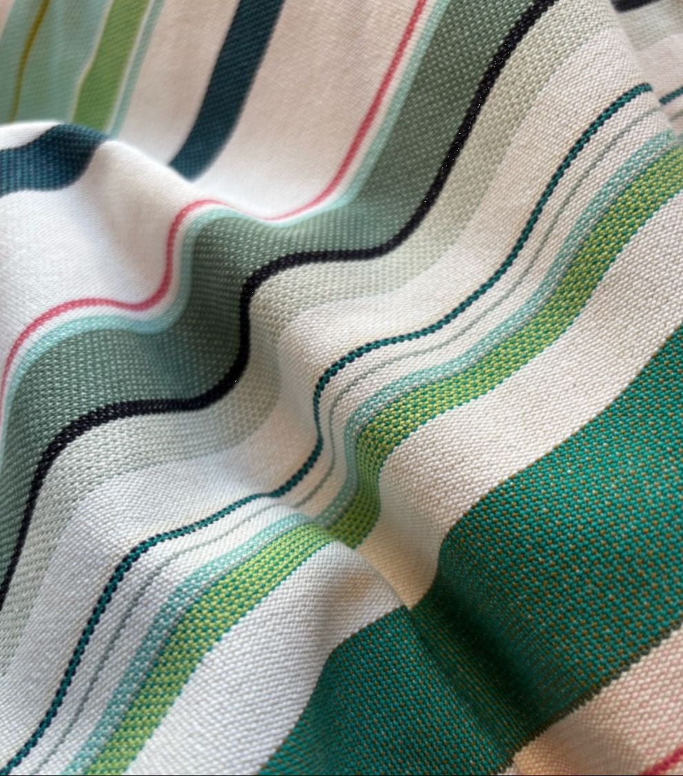Les Toiles du soleil Bompas range of indoor cotton fabric roll. This multi coloured striped fabric palette is made up of greens, light blues, soft pinks and white 