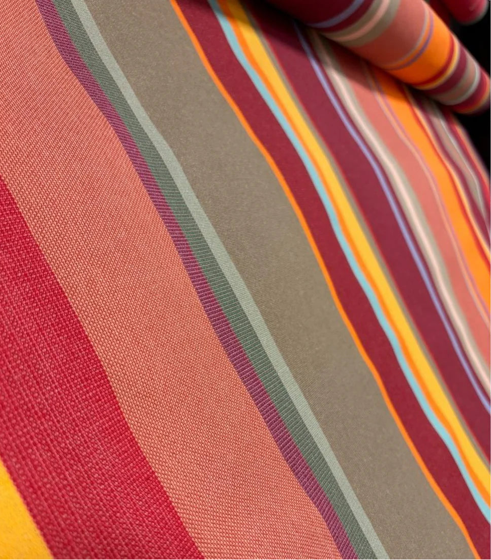 Close-up of Collioure Rouge Les Toiles du Soleil 100% cotton fabric with multicolored stripes in red, orange, yellow, and green.