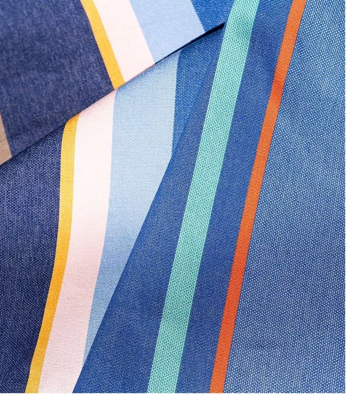 Close-up of Collioure Roy 100% cotton  Les toiles du Soleil fabric roll. Multi coloured striped with blues shades yellow, beige and red