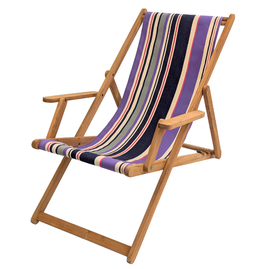Teak deckchair with arms featuring a cotton Les Toiles du Soleil fabric of multicoloured purple, navy, cream, and grey stripes, on a white background.