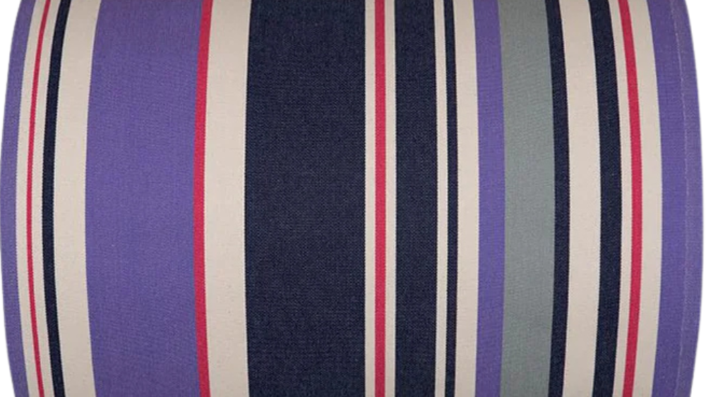 Roll of cotton fabric featuring navy, violet, and ivory stripes accented by fine crimson lines.