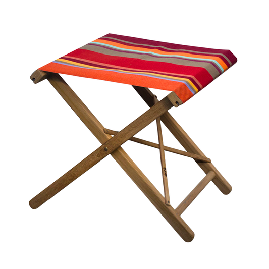 Teak folding stool with Collioure Rouge cotton fabric canvas. Featuring vibrant stripes of warm shades and a pop of blue and turquoise. On a white background