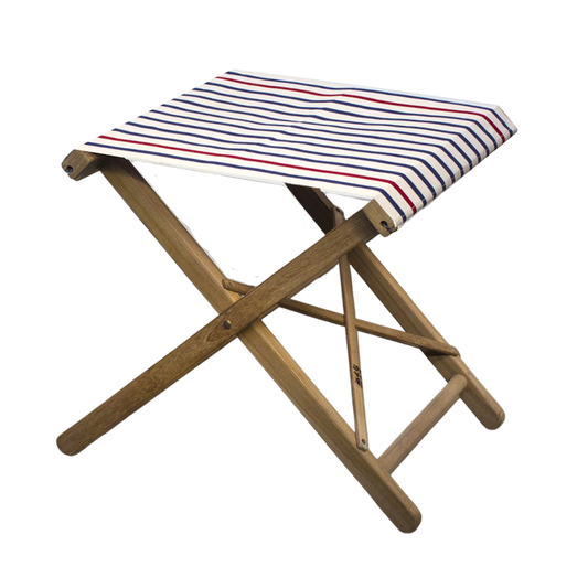 A folding teak stool with a striped blue, red and ecru/natural cotton canvas seat and backrest, displayed against a plain background.