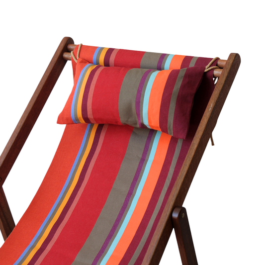 A striped head cushion with red, orange, and blue colours, placed on a wooden deck chair.