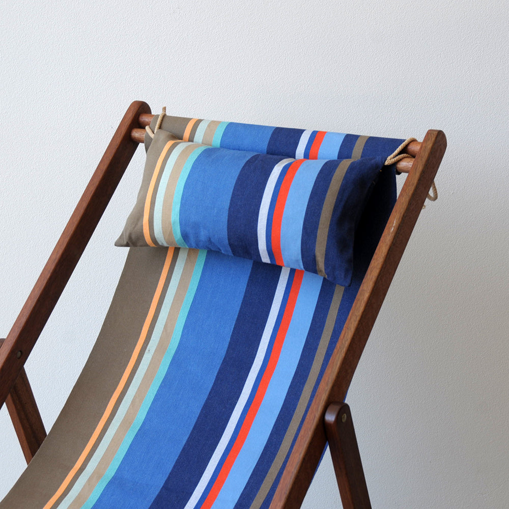 Ici et la Deckchair and head pillow made from Collioure Roy - a fabric featuring a striped pattern with various bands in different shades of blue, beige, brown and red. A detailed 100% cotton weave by By Les Toiles du Soleil 