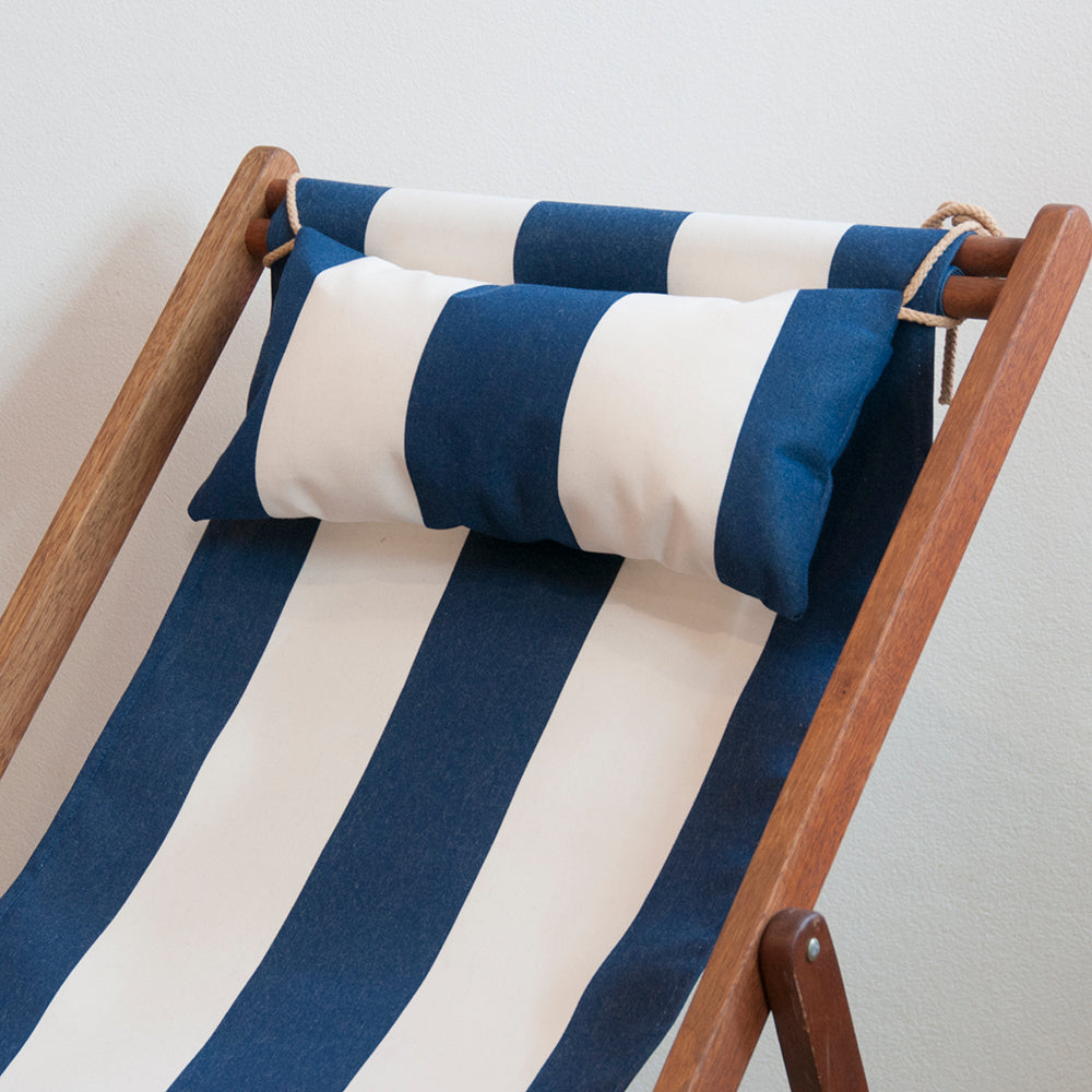 Close up of Ici et La of deckchair with head pillow in matching Sunbrella Navy & cream striped outdoor fabric 