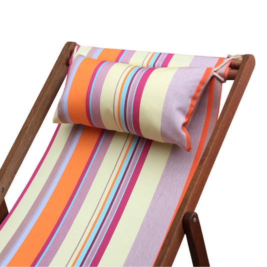 An acrylic striped head cushion in orange, pink, and yellow, placed on a wooden deckchair.