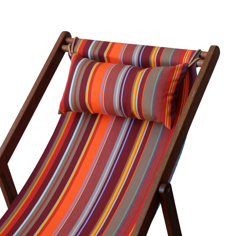 A striped multicolour head cushion placed on a wooden deck chair, with a pattern that includes shades of red, orange, yellow, green, and gray.