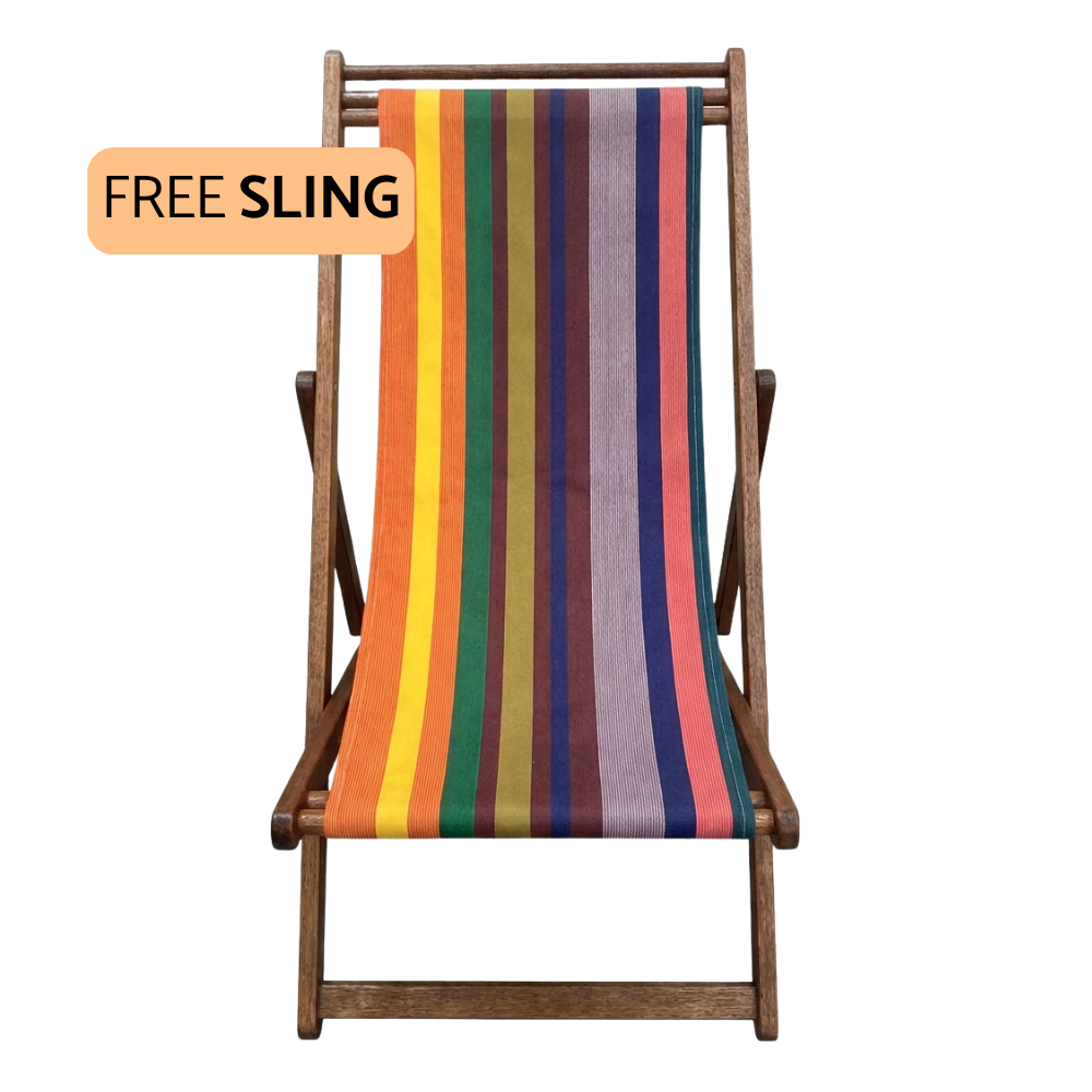 A wooden folding deck chair with a colorful vertically striped sling seat, shown on a plain white background with an orange badge that reads 'FREE SLING'.