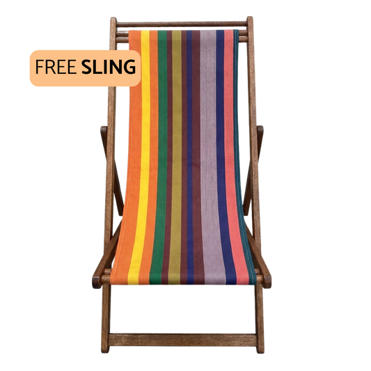 A wooden folding deck chair with a colorful vertically striped sling seat, shown on a plain white background with an orange badge that reads 'FREE SLING'.