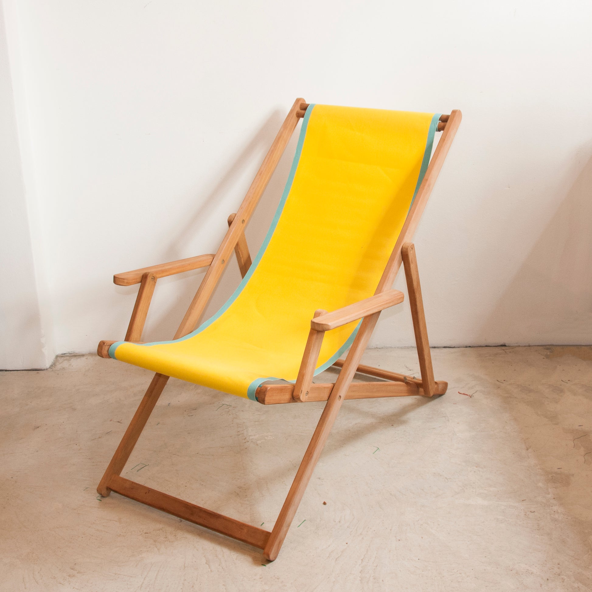 Ici et la teak deckchair with arms made from yellow Les Toiles du Soleil 100 % cotton fabric with a turquoise border fabric roll
