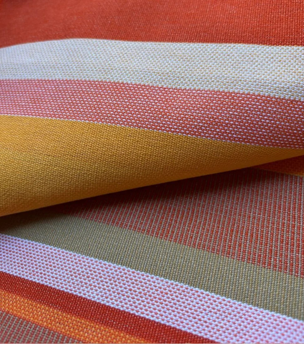 Close up of L'Apricot 100% cotton fabric by Les Toiles du Soleil. Warm coloured textured woven striped fabric