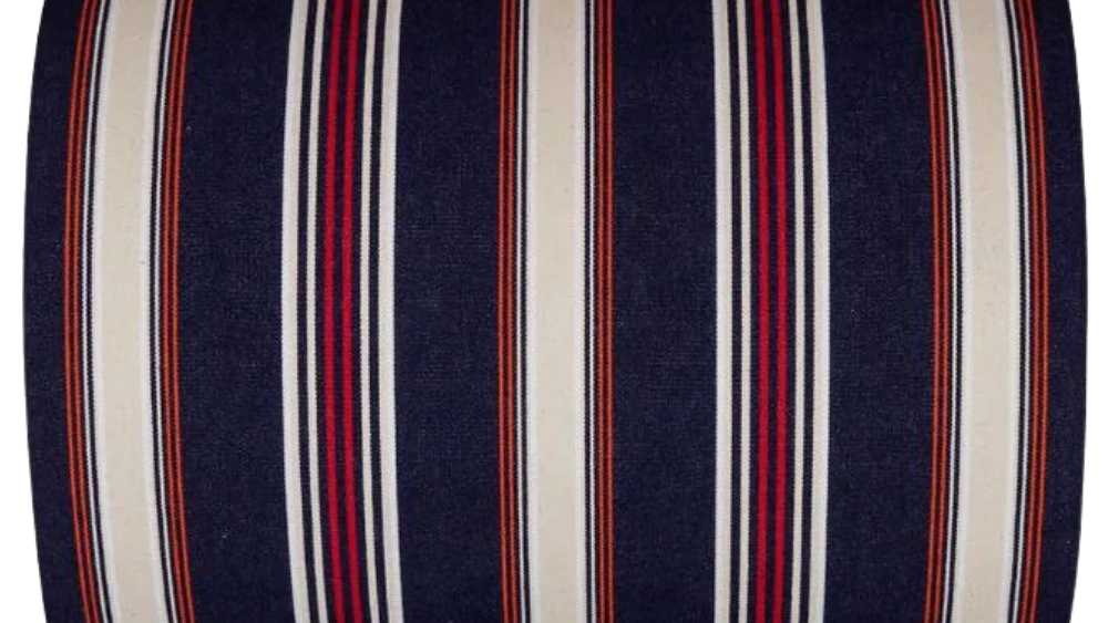 Fabric roll with deep navy with fine stripes of écru/cream, red, orange and black. On a white background