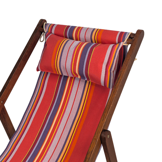 Hardwood folding stool featuring a matching head cushions with colourful multi-striped cotton fabric showcasing vibrant pinks, lavender, purple, yellow, and orange. Petit Sixtine is a fabric made by Les Toiles do Soleil. Placed on a white background