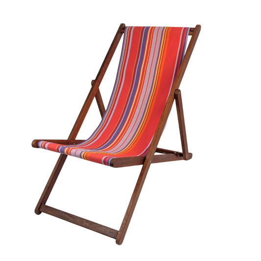 Hardwood folding deckchair with colourful multi-striped cotton fabric showcasing vibrant pinks, lavender, purple, yellow, and orange. Petit Sixtine is a fabric made by Les Toiles do Soleil. Placed on a white background