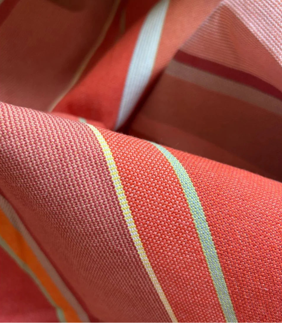 Close up photo of Les Toiles du Soleil 100% cotton Pezilla-la-rivière fabric. Striped with Multi colours - ight stone and terracotta, soft greens, subtle rusts and the patinated reds.