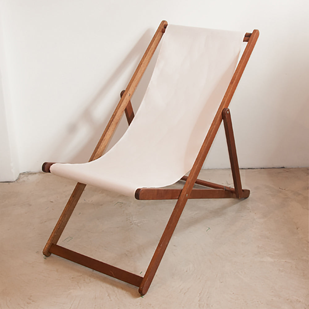 Natural coloured Sunbrella outdoor fabric sling placed on an ici et la wooden deckchair