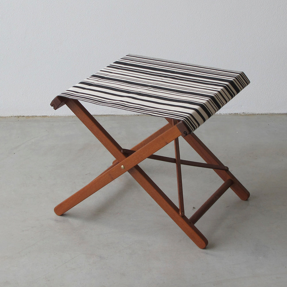ici et la folding stool with 43cm cotton Tom Black fabric featuring a multicoloured striped pattern of black and white. A barcode-inspired look by Les Toiles du Soleil
