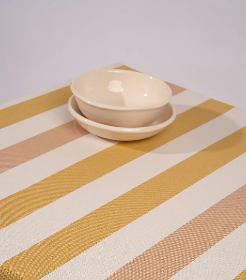 Raspail Miel Les Toiles du Soleil 100% cotton yellow, white and muted pink striped fabric tablecloth with 2 ceramic bowls