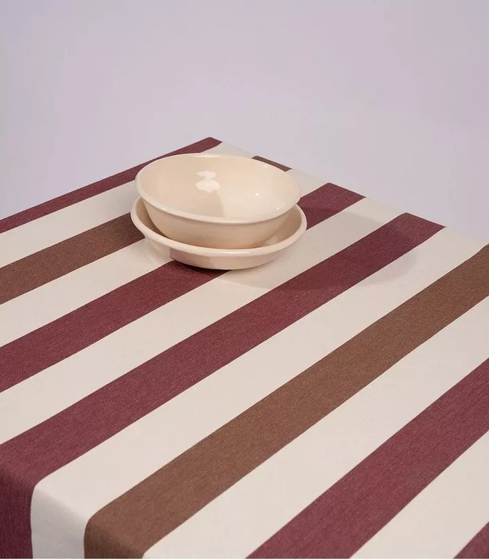Les Toiles du Soleil Raspail Prunelle 100% cotton striped fabric of plum, browns and white table cloth with 2 ceramic white bowls