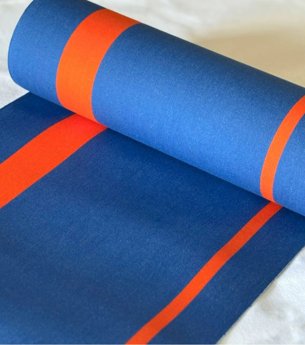 Rue du Soleil is a cotton fabric roll in vivid cobalt blue with fine bright orange accent stripes. Made by Les Toiles do Soleil. 