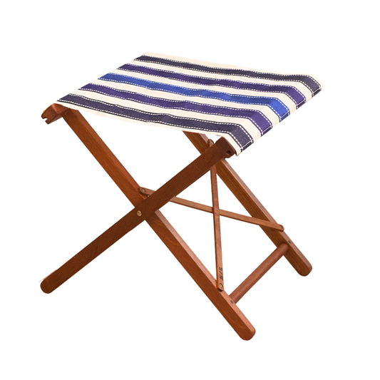 A folding hardwood stool with a striped cotton fabric, featuring a combination of blue and white stripes with detail. On a white background