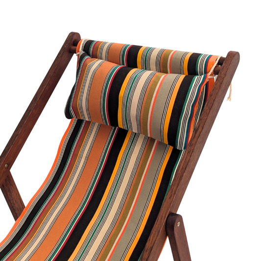 Close up of head cushion on Hardwood deckchair. Cotton fabric roll featuring densely woven stripes of orange, dark brown, golden yellow, teal, sand, olive, red and cream, with fine black and white pin lines throughout and bright orange selvedge edges. On white background
