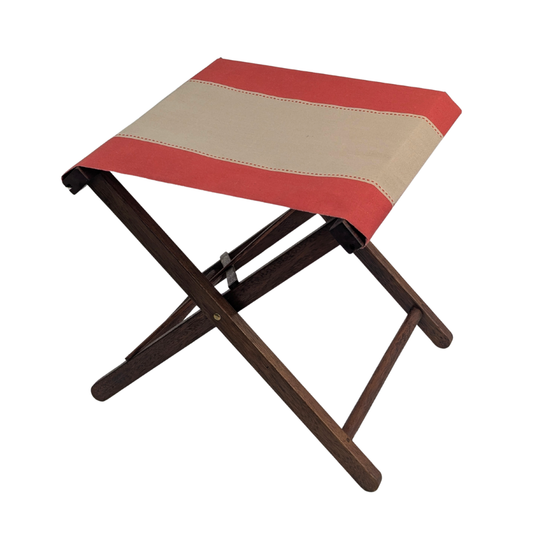 A hardwood folding stool with a red and beige striped cotton canvas by Les Toiles du Soleil. Shown on a plain white background.