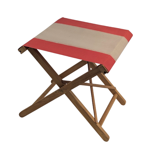 A folding stool with a red and beige striped cotton canvas seat by Les Toiles du Soleil, and a teak wooden frame, shown on a plain white background.