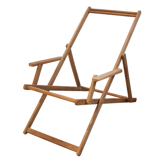 A teak wood frame of a deckchair with arms, positioned in a reclined state on a concrete floor against a white wall.